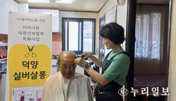 ‘찾아가는 덕양 실버살롱' 자원봉사자가 어르신의 머리를 다듬고 있다.