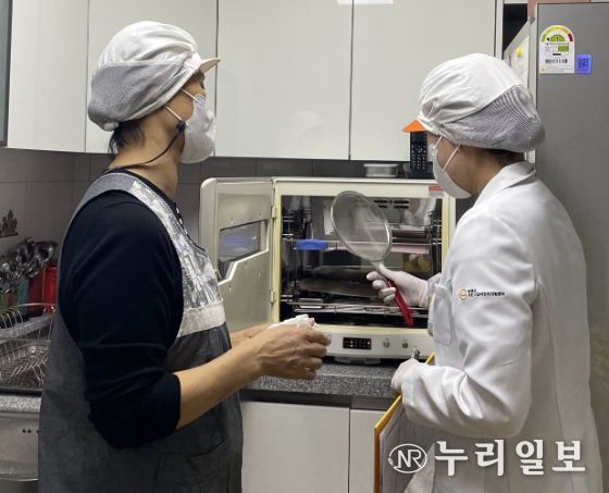 어린이 기호식품 전담관리원이 어린이집 집단급식소에서 위생 점검을 실시하고 있다.