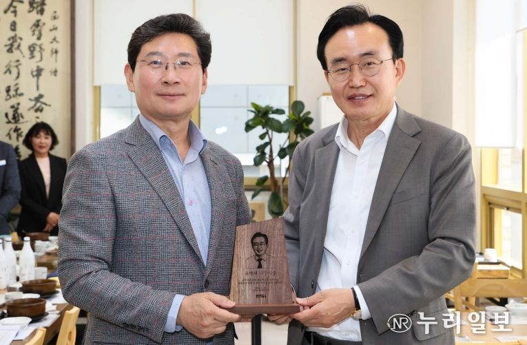 25일 이상일 용인특례시장(왼쪽)이 윤병태 나주시장에게 목재 기념패를 전달하고 있다.