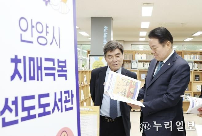 2025년 4월9일 석수도서관에서 열린 치매극복 선도도서관 지정 현판식에 참석한 최대호 안양시장이 도서를 살펴보고 있다
