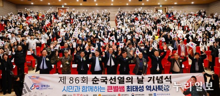 광주시교육감 이정선이 17일 광주광역시교육청교육연수원 대강당에서 열린 ‘광복 80주년, 제86회 순국선열의 날 기념식’에서 태극기를 흔들며 기념사진을 촬영하고 있다.