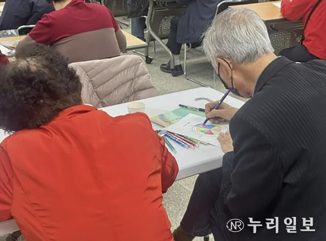 웰다잉교육에 참여한 시민이 내 삶을 돌아보는 노트를 작성 중이다